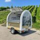Wine sales trailer with open sales flap in front of the vineyards 